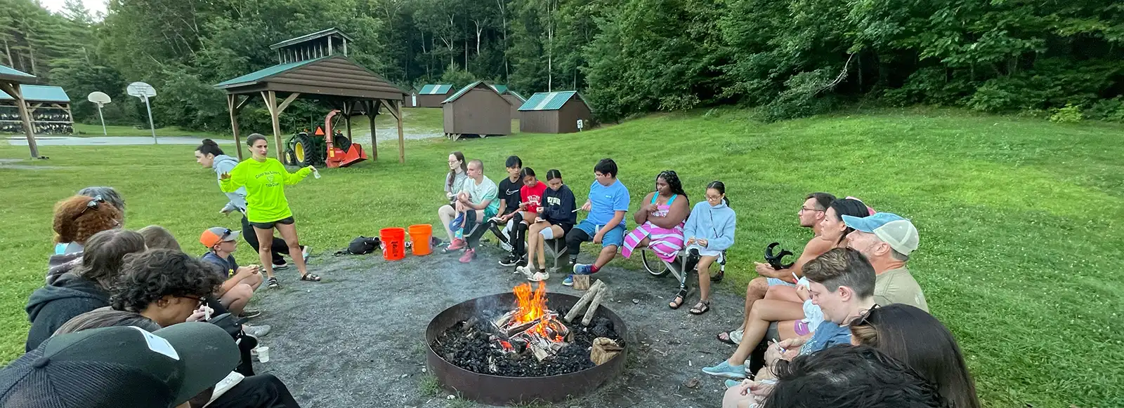 Youth group sitting around campfire.
