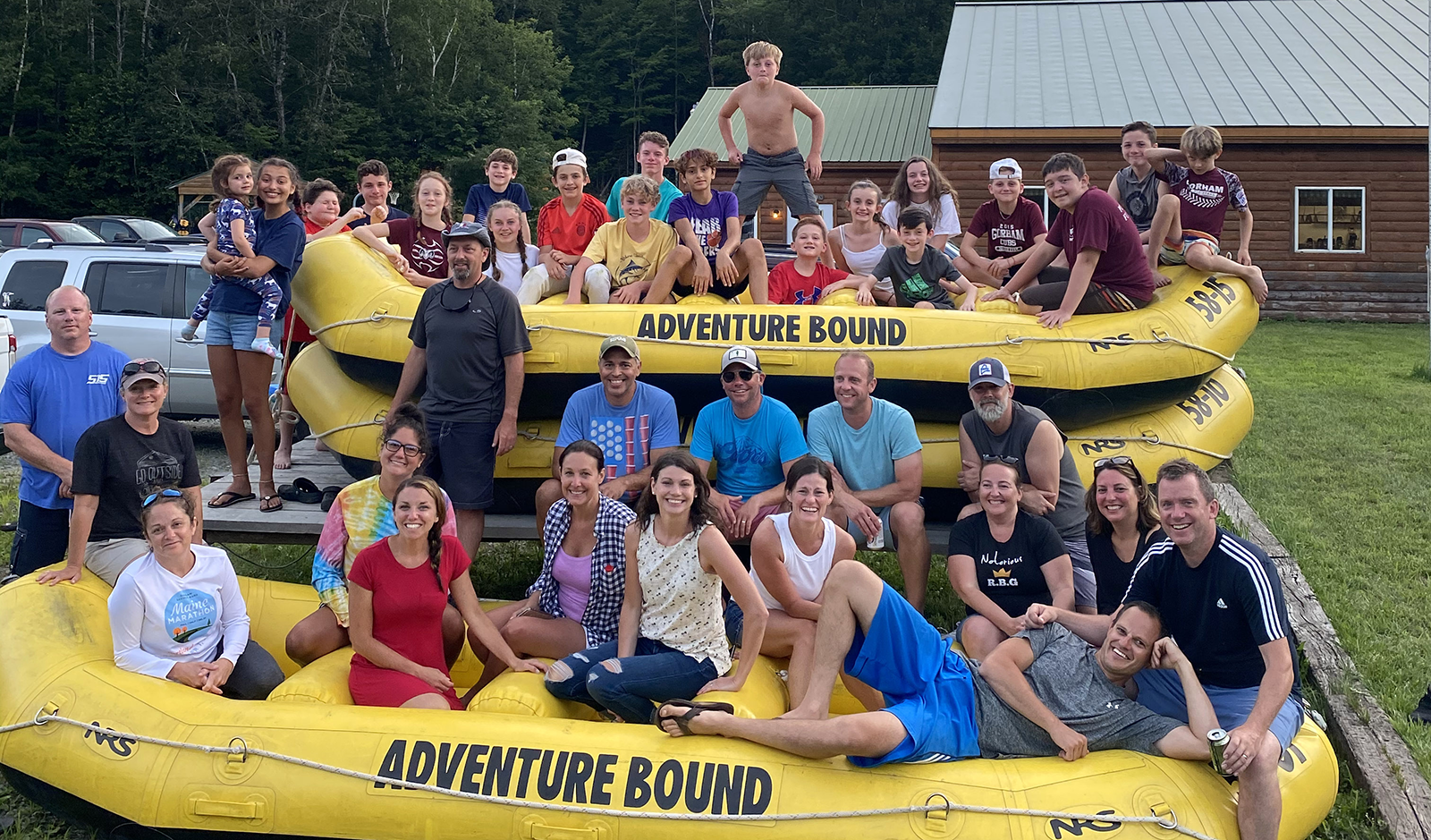 Kids and family rafting at Adventure Bound, family group sitting on a few yellow rafts stacked up.
